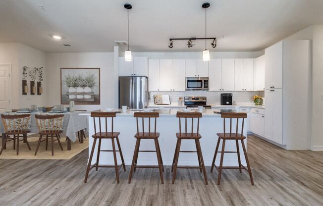 a kitchen and dining area with bar stools in a living room with a kitchen