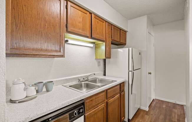 A kitchen with wooden cabinets and a white refrigerator.