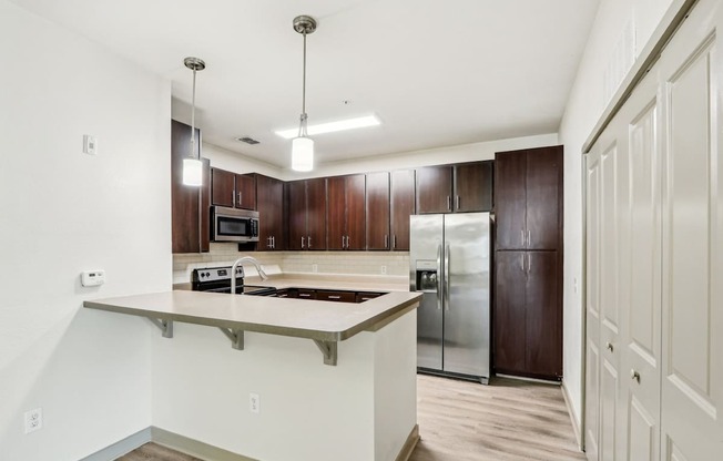 Royal Palm kitchen with dark wood cabinets and a bar counter at Oakleaf Plantation Apartments in Jacksonville, FL