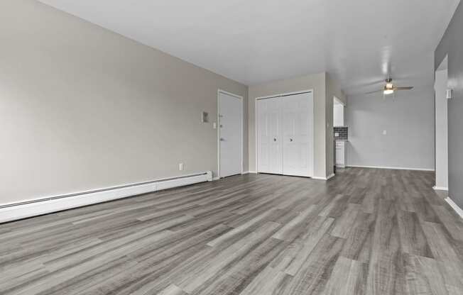 the living room and dining room of an empty house with wood flooring