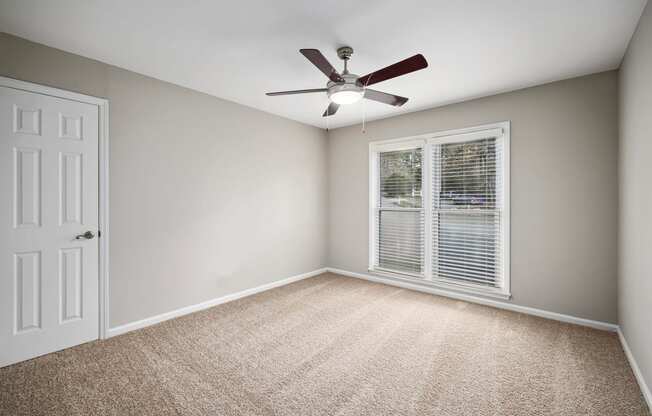 bedroom with large picture window and ceiling fan