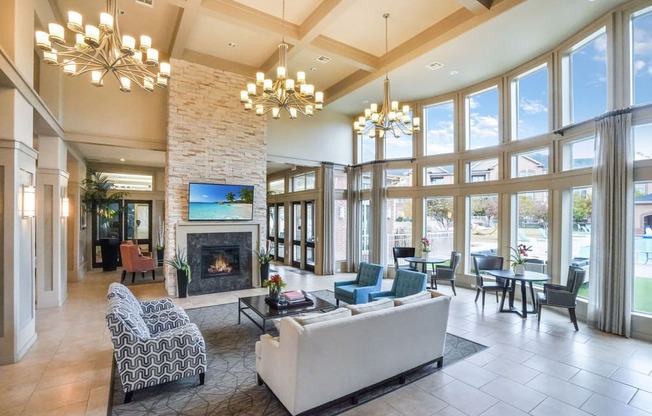 a resident clubhouse with a fireplace and large windows with sitting area