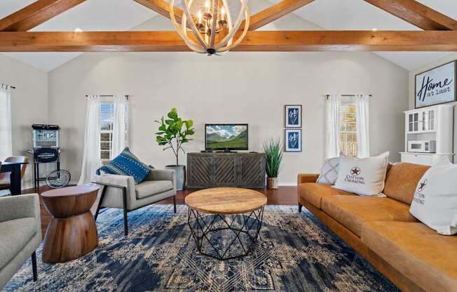 A living room with a brown couch, a coffee table, and a chandelier.
