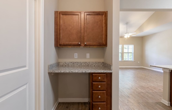 an empty kitchen with wooden cabinets and granite counter top