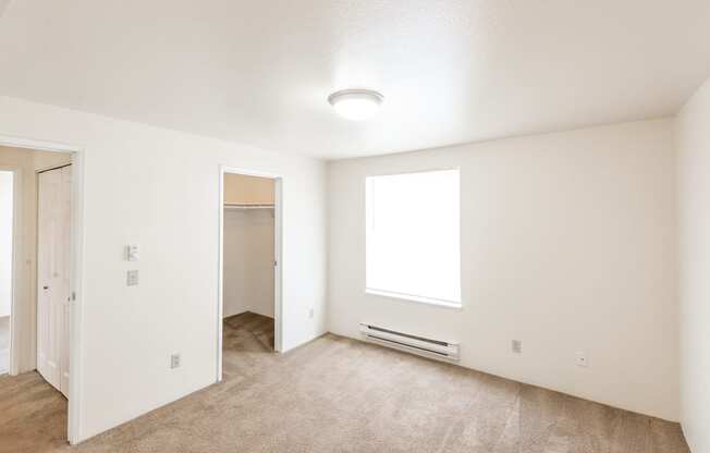 a bedroom with white walls and carpet