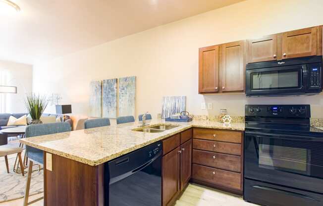 a kitchen with black appliances and a granite counter top at Sugar House Apartments By Urbana, Salt Lake City, UT, 84105