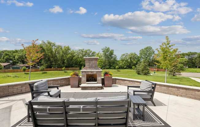 a patio with chairs and a fire pit