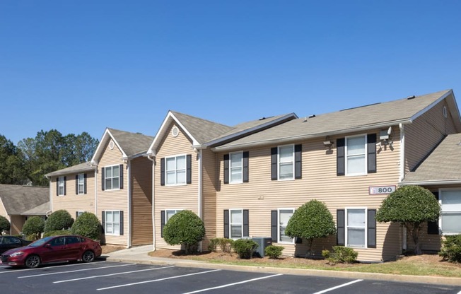 a row of houses with cars parked in a parking lot