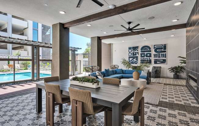A modern dining room with a pool in the background.