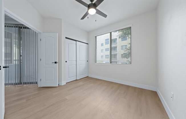 a bedroom with hardwood floors and a ceiling fan