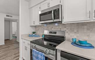 A kitchen with a stove top oven and a microwave above it.