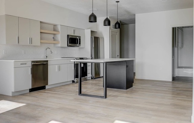 an empty kitchen with an island in the middle of it
