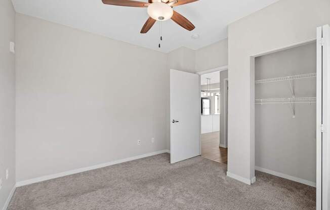 A room with a ceiling fan and carpeted floor.