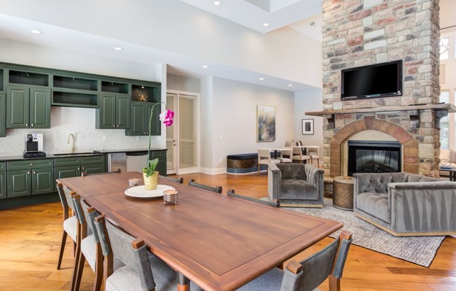 a dining area with a wooden table and chairs and a fireplace with a tv above it