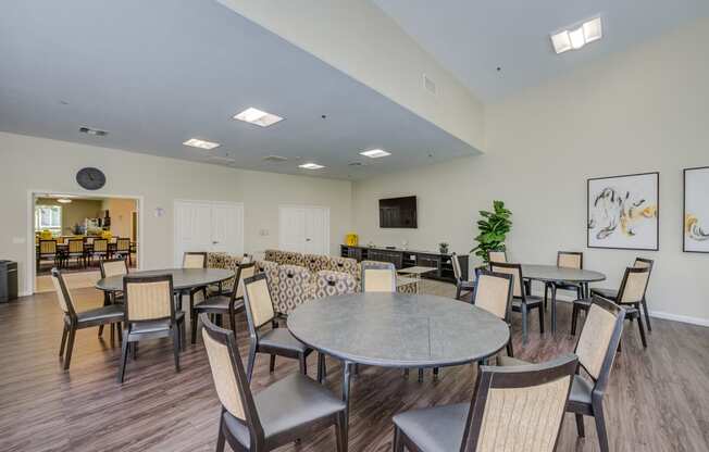 a resident clubhouse with tables and chairs and a flat screen tv