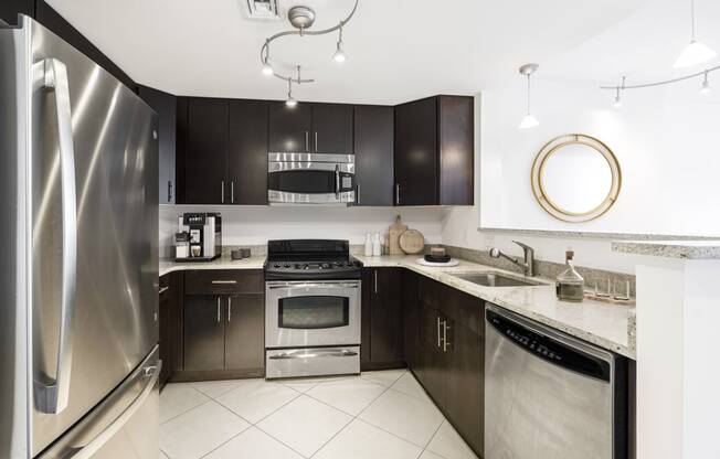 a kitchen with stainless steel appliances and black cabinets