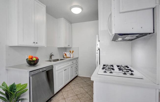 a kitchen with white cabinetry and a white stove top oven