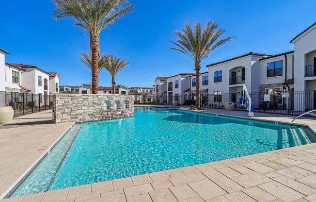 our apartments have a large swimming pool with palm trees at Stella Luxury Apartment Homes, San Tan Valley, AZ