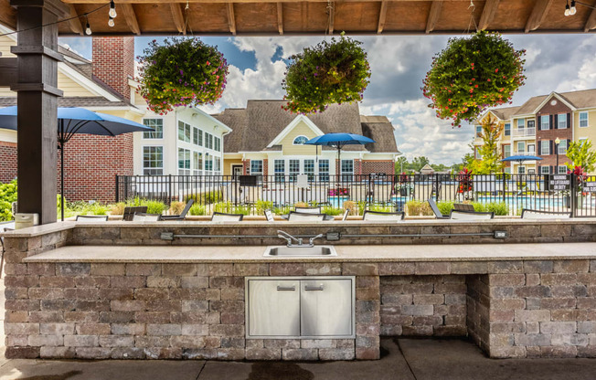 a large outdoor kitchen with a sink and a patio with umbrellas