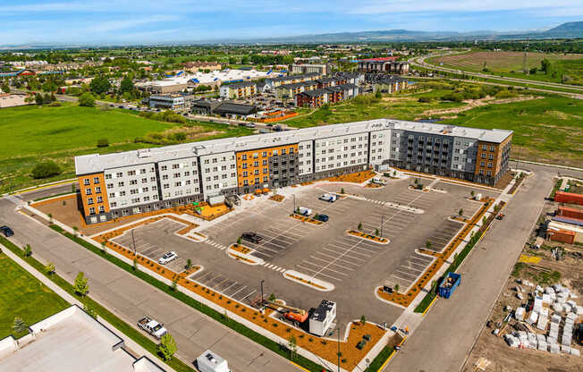 A large parking lot is surrounded by apartment buildings.