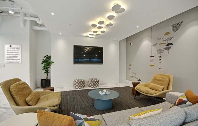 a living room with couches chairs and a table at Link Apartments® Calyx, Chapel Hill, NC