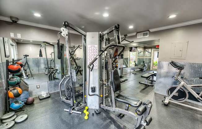 a gym with weights and cardio equipment on the floor and a door