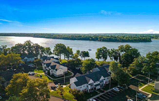 A bird's eye view of a residential area with houses and a lake in the background.