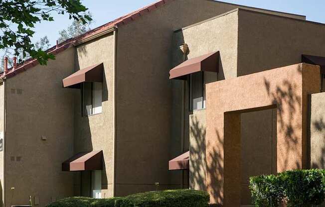 A building with beige walls and red awnings.