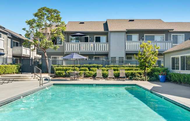 a swimming pool with a house in the background