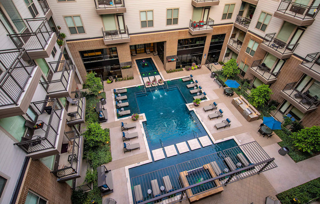 an aerial view of an apartment building with a large pool