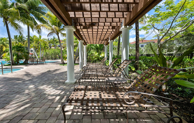 a row of wooden benches sitting under a covered porch