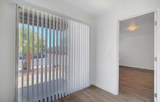 A room with a sliding door and a window with blinds.