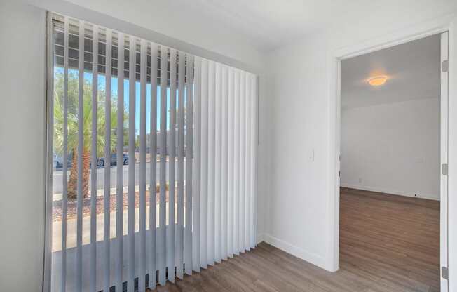 A room with a sliding door and a window with blinds.