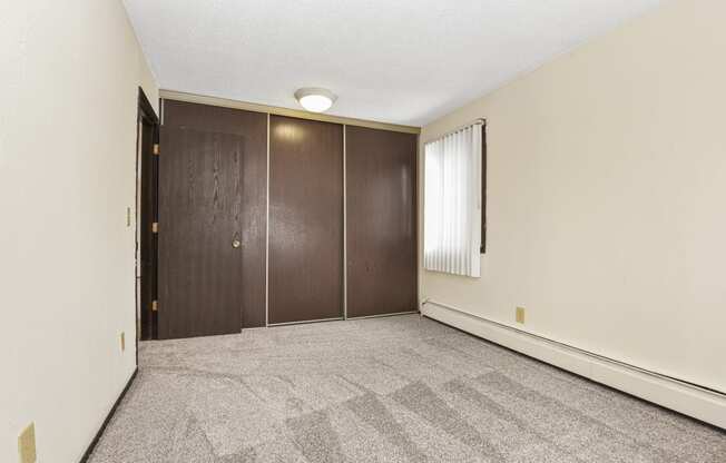 Fridley, MN Georgetown Apartments. A bedroom with two doors and a carpeted floor