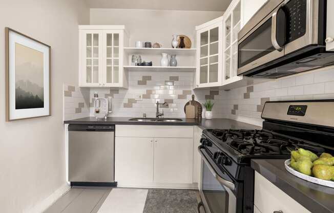 a kitchen with stainless steel appliances and white cabinets at Del Mor Apartments, Los Angeles, CA, 90026