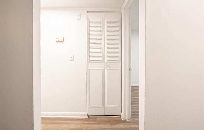 a room with a white door and a closet