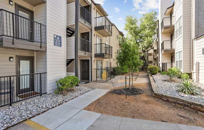 Apartment complex with a tree in the middle of the courtyard.