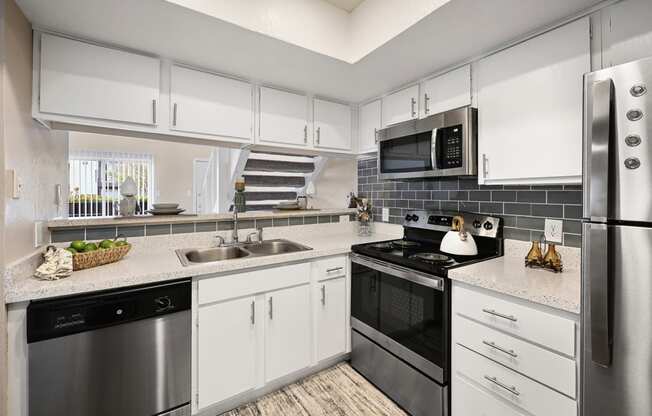 a kitchen with white cabinets and stainless steel appliances