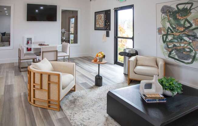 A living room with a black coffee table and a large painting on the wall at Evergreen Luxury Apartments, Merrillville, IN