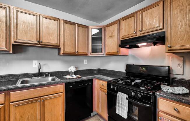 a kitchen with black appliances and wooden cabinets