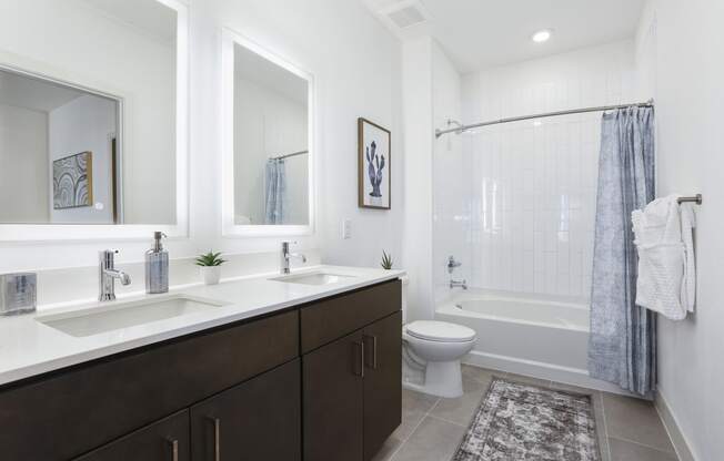 a bathroom with two sinks and a shower and a toilet