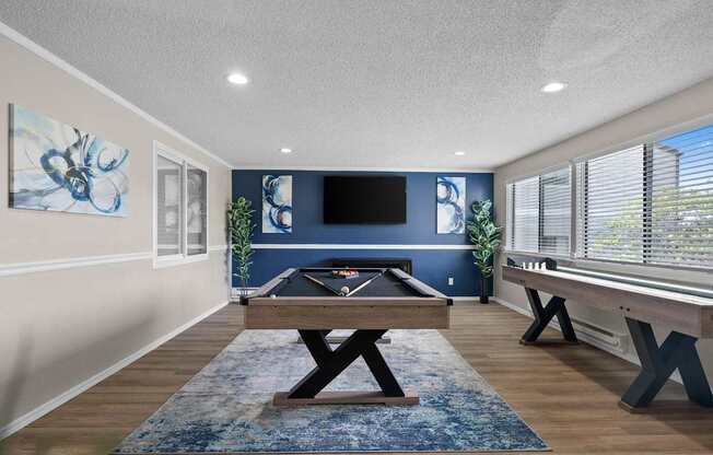 A room with a blue rug and a wooden table.