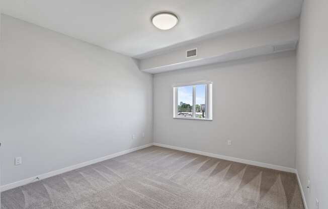 an empty room with white walls and a window