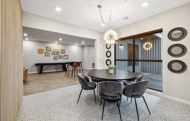 a dining area with a round table and chairs and a glass sliding door