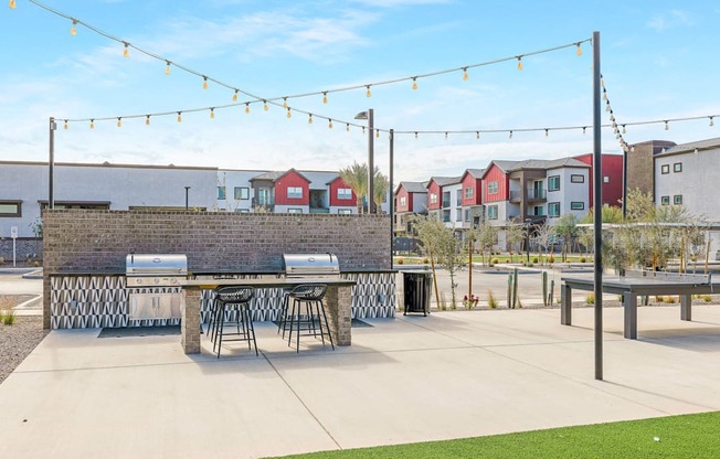 A patio area with a table and chairs under string lights.