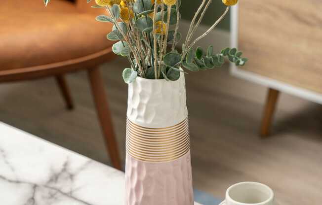 a vase with yellow flowers on a table