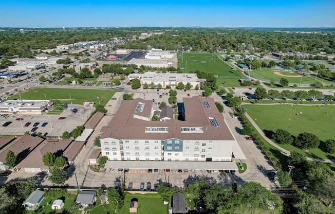 an aerial view of a campus with a field and buildings