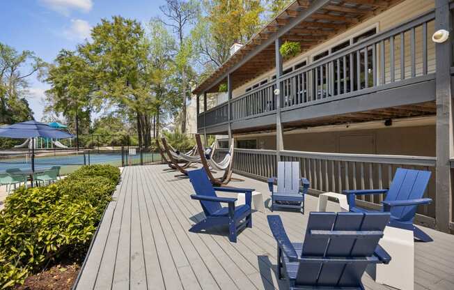 a deck with blue chairs and a house with a pool