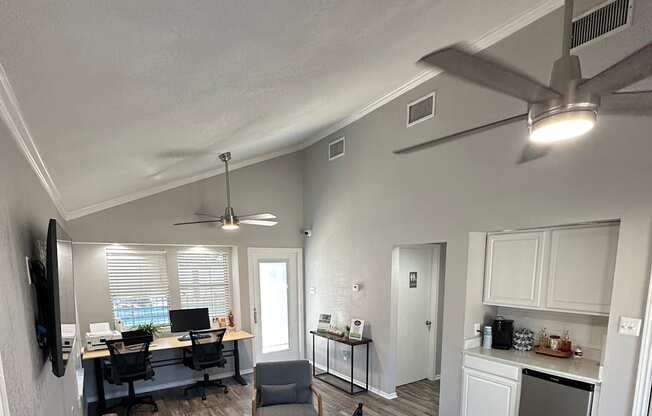 A living room with a brown couch and a fan on the ceiling.