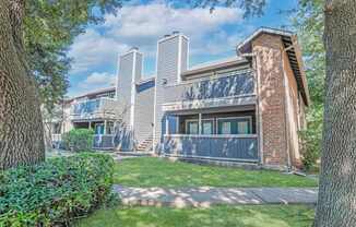 A house with a grey facade and a brick chimney.